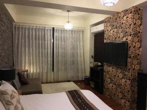 a bedroom with a bed and a flat screen tv at Near Seaside B&B in Hualien City