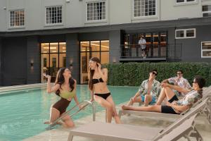 a group of people in bathing suits in a swimming pool at Pranakorn Heritage Hotel in Bangkok