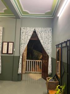 um quarto com uma porta e uma janela com cortinas em Trại Hoa Vàng Homestay at Tuy Hòa Phú Yên em Ðông Tác (1)