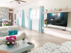 uma sala de estar com um sofá e uma televisão em Hermosa Casa en Chelem A 5 min Caminando de Playa em Chelem