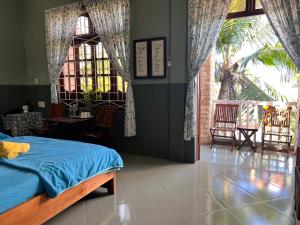 een slaapkamer met een bed en een groot raam bij Trại Hoa Vàng Homestay at Tuy Hòa Phú Yên in Ðông Tác (1)