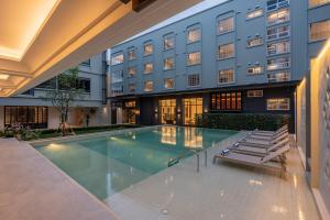 a swimming pool in front of a hotel at Pranakorn Heritage Hotel in Bangkok