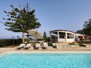 a swimming pool with chairs and a tree and a gazebo at Igloo Home Plemmirio with Sea Access & Pool in Plemmirio