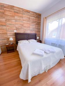 sypialnia z dużym łóżkiem z ręcznikami w obiekcie Hostal Alcala w mieście Temuco