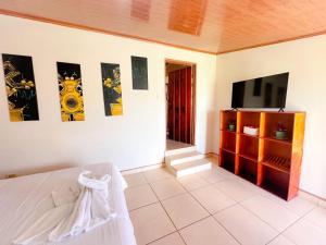 ein Wohnzimmer mit einem Bett und einem Fernseher in der Unterkunft Kiwi House in Monteverde Costa Rica