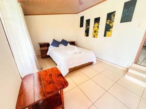 ein Schlafzimmer mit einem Bett und einem Tisch darin in der Unterkunft Kiwi House in Monteverde Costa Rica