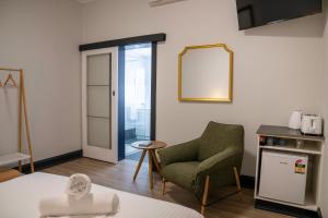 a living room with a chair and a mirror at The Rec Hotel Waroona in Waroona