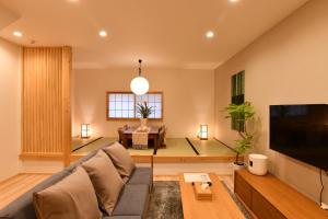 a living room with a couch and a tv at FL House Naniwacho - Vacation STAY 13598 in Osaka