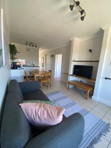 uma sala de estar com um sofá e uma mesa em Castleton Plettenberg Bay em Plettenberg Bay