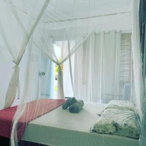 a bedroom with a canopy bed with towels on it at Pousada Obedemar - Taipu de fora, Barra Grande, Ba in Barra Grande +88 photos