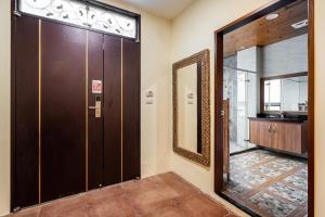 a bathroom with a large mirror and a door at Songyuan 68 Villa in Hualien City