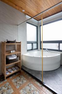 a large bathroom with a tub and a window at Songyuan 68 Villa in Hualien City