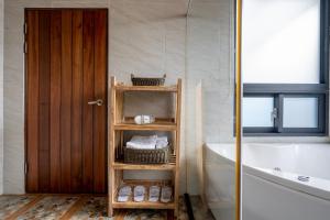 a bathroom with a wooden shelf next to a bath tub at Songyuan 68 Villa in Hualien City