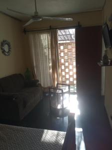 een woonkamer met een bank en een raam bij Los Tilos in Colonia del Sacramento
