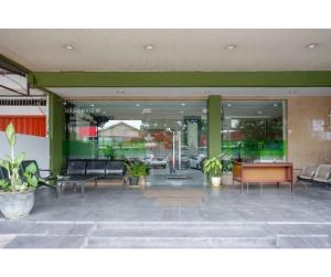 a lobby with chairs and a table in a building at Capital Hotel Makassar in Pampang