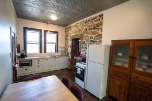 Il comprend une cuisine équipée d'une table en bois et d'un réfrigérateur blanc. dans l'établissement Whispering Pines, à Albany