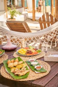 einen Tisch mit Teller mit Speisen darüber in der Unterkunft Mangata Beach in Cartagena de Indias