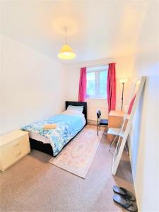Schlafzimmer mit einem Bett, einem Schreibtisch und einem Fenster in der Unterkunft London Rooms in London