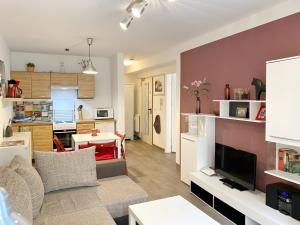 Stralsund - Haus Gohr, Quartier 2 في شترالزوند: غرفة معيشة مع أريكة وتلفزيون ومطبخ
