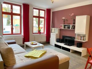 Stralsund - Haus Gohr, Quartier 1 في شترالزوند: غرفة معيشة مع أريكة وتلفزيون