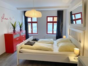 - une chambre avec deux lits et une commode rouge dans l'établissement Stralsund - Haus Gohr, Quartier 3, à Stralsund