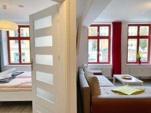 Stralsund - Haus Gohr, Quartier 1 في شترالزوند: غرفة معيشة مع أريكة وسرير