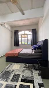 a bedroom with a bed and a window and a rug at Homestay Dyzas in Batu Caves
