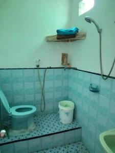 a bathroom with a toilet and a bucket at Ocean Holiday liukang in Bira