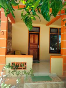 uma casa com um alpendre com uma porta em Ocean Holiday liukang em Bira
