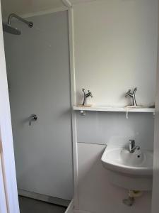 a white bathroom with a sink and a toilet at Huriana Place in Kaitaia