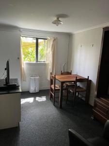 a room with a table and chairs and a window at Huriana Place in Kaitaia