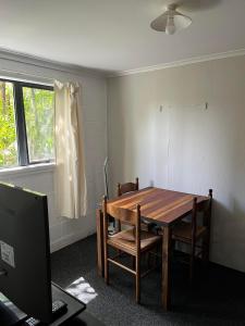 a room with a wooden table and a laptop computer at Huriana Place in Kaitaia