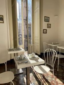 Zimmer mit einem Tisch, Stühlen und Fenstern in der Unterkunft Fera O' Luni in Catania