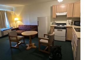 a kitchen with a table and a dog in a kitchen at Oakridge Motel in Newaygo