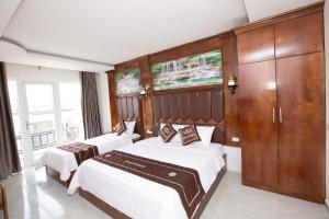 a hotel room with two beds and a cabinet at Vientiane Garden Villa Hotel And Restaurant in Vientiane