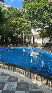 a large blue swimming pool with people in the water at Vientiane Garden Villa Hotel And Restaurant in Vientiane
