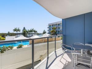 a balcony with chairs and a swimming pool at Nesuto Apartments - Unit 532 in The Entrance