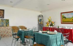 a dining room with tables and chairs with red tablecloths at New Orleans Tagaytay in Tagaytay