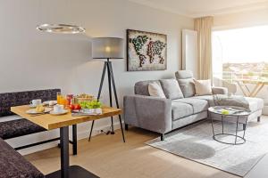 ein Wohnzimmer mit einem Sofa und einem Tisch in der Unterkunft Haus Norderhoog Wohnung 67 - "Zoe's Nest"  in Westerland