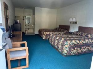 a hotel room with two beds and a television at Oakridge Motel in Newaygo