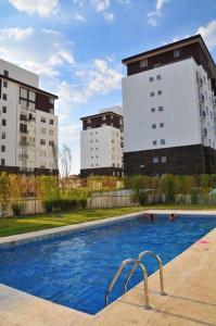basen przed dwoma wysokimi budynkami w obiekcie Depa equipado y piscina calientita en Juriquilla w mieście Jurica