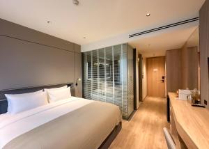 una camera da letto con un grande letto bianco e una finestra di La Green Hotel and Residence a Bang Tao Beach