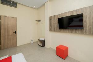 a room with a flat screen tv on a wall at RedDoorz @ Sangnala Homestay Pakisaji in Malang +15 photos