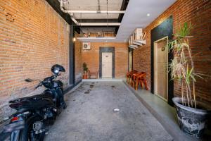 a motorcycle parked in a room with a brick wall at RedDoorz @ Sangnala Homestay Pakisaji in Malang