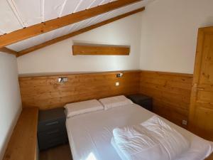 1 dormitorio con 1 cama en una habitación con paredes de madera en Appartement Montgenèvre, 2 pièces, 4 personnes - FR-1-445-202, en Montgenèvre