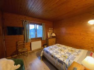 a bedroom with a bed and a wooden wall at Appartement Crest-Voland, 3 pièces, 5 personnes - FR-1-733-148 in Crest-Voland
