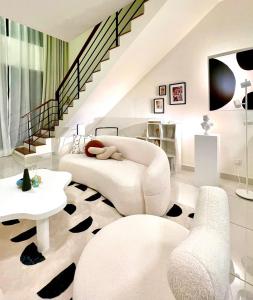 una sala de estar con muebles blancos y una escalera. en Arte Mont Kiara by Keys Properties, en Kuala Lumpur