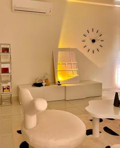 sala de estar con silla y reloj en la pared en Arte Mont Kiara by Keys Properties, en Kuala Lumpur