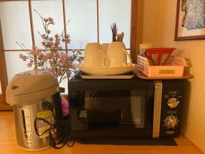 a microwave with plates and dishes on top of it at Hotel EL Shinjuku 6 in Tokyo