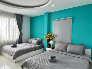 2 camas en un dormitorio con paredes azules en Thắng Hà Hotel, en Ho Chi Minh